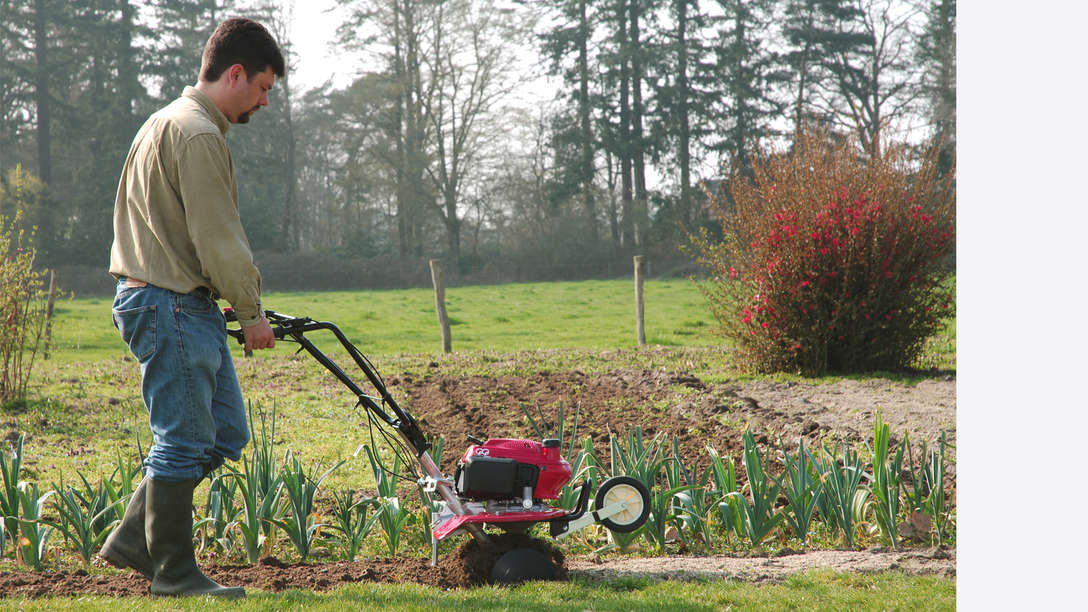 Mini-motozappa, rivolta a destra, utilizzata da un operatore, luogo di utilizzo: giardino.